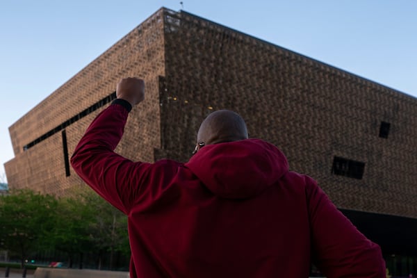 Pastor Robert Turner walks past the National Museum of African American History and Culture as part of his monthly walk from Baltimore to Washington to raise awareness of reparations on Wednesday, April 16, 2025, in Washington. (AP Photo/Nathan Howard)