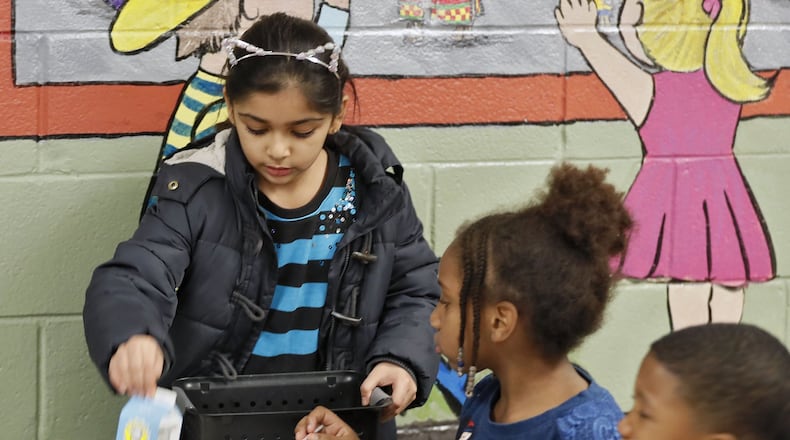 Anya Endrabi collects unopened food from classmates in the Mason Elementary School cafeteria in Duluth. The school’s effort to reduce waste include a food sharing table with a designated refrigerated area for milk and other perishables that haven’t been opened, and a self-serve area for vegetables and sides, to encourage students to serve themselves only what they intend to eat. It also plans to have a compost area, built by an Eagle Scout, which they will begin using later in the year. BOB ANDRES / BANDRES@AJC.COM