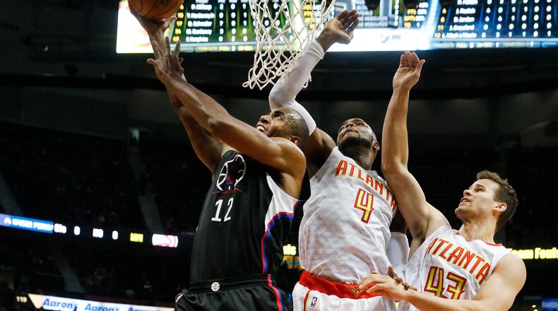 LA Clippers forward Luc Mbah a Moute (12) goes to the basket against Atlanta Hawks forward Paul Millsap (4) and forward Kris Humphries (43) in the first half of an NBA basketballgame Monday, Jan. 23, 2017, in Atlanta. (AP Photo/John Bazemore)