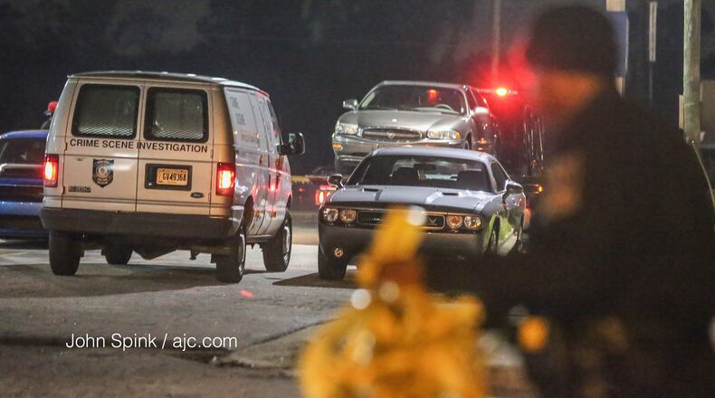 Police tow a car left at the Gulf American Inns after a shooting at the motel.