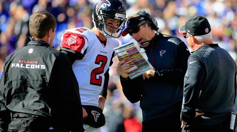BALTIMORE, MD - OCTOBER 19: Quarterback Matt Ryan #2 of the Atlanta Falcons talks with offensive coordinator Dirk Koetter and head coach Mike Smith (R) in the first half of a game against the Baltimore Ravens at M&T Bank Stadium on October 19, 2014 in Baltimore, Maryland. (Photo by Rob Carr/Getty Images)