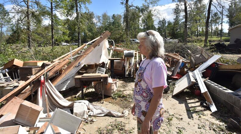 Sharon Granade stands on destroyed two-car garage after Tropical Storm Michael passed in Roberta, Ga., on Oct. 11, 2018. Tropical Storm Michael swept out of Georgia before sunrise that day, leaving a trail of destruction in its wake. HYOSUB SHIN / HSHIN@AJC.COM