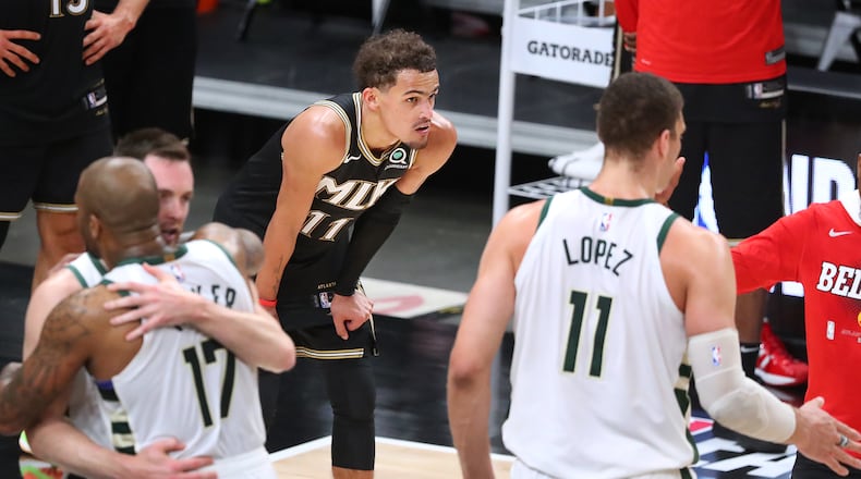Hawks guard Trae Young is alone with his thoughts as the Milwaukee Bucks celebrate their 118-107 victory in Game 6 of the NBA Eastern Conference Finals, as they advance to play for a championship.   “Curtis Compton / Curtis.Compton@ajc.com”