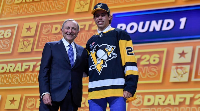 Liam Ruck, right, stands with NHL Commissioner Gary Bettman after being drafted by the Pittsburgh Penguins during the NHL hockey draft Friday, June 26, 2026, in Buffalo, N.Y. (AP Photo/Adrian Kraus)