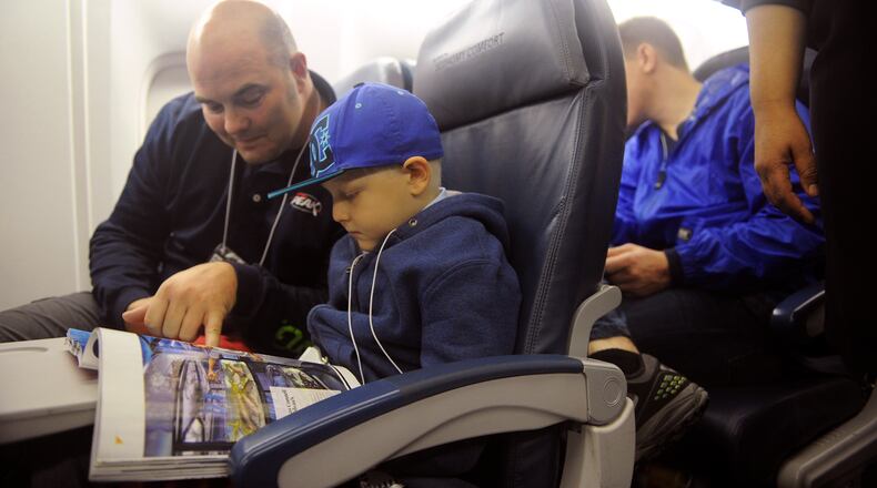 Dec. 6, 2014, Atlanta: Richmond Davis and his son Jake, 7, read a magazine together as they wait for flight 9707 to take off at Hartsfield-Jackson Atlanta International Airport's Maynard H. Jackson International Terminal Saturday, Dec. 6, 2014. Delta and Children's Healthcare of Atlanta "flew" about 40 children from the Atlanta area to the "North Pole" to visit Santa's village Saturday. BITA HONARVAR / BHONARVAR@AJC.COM