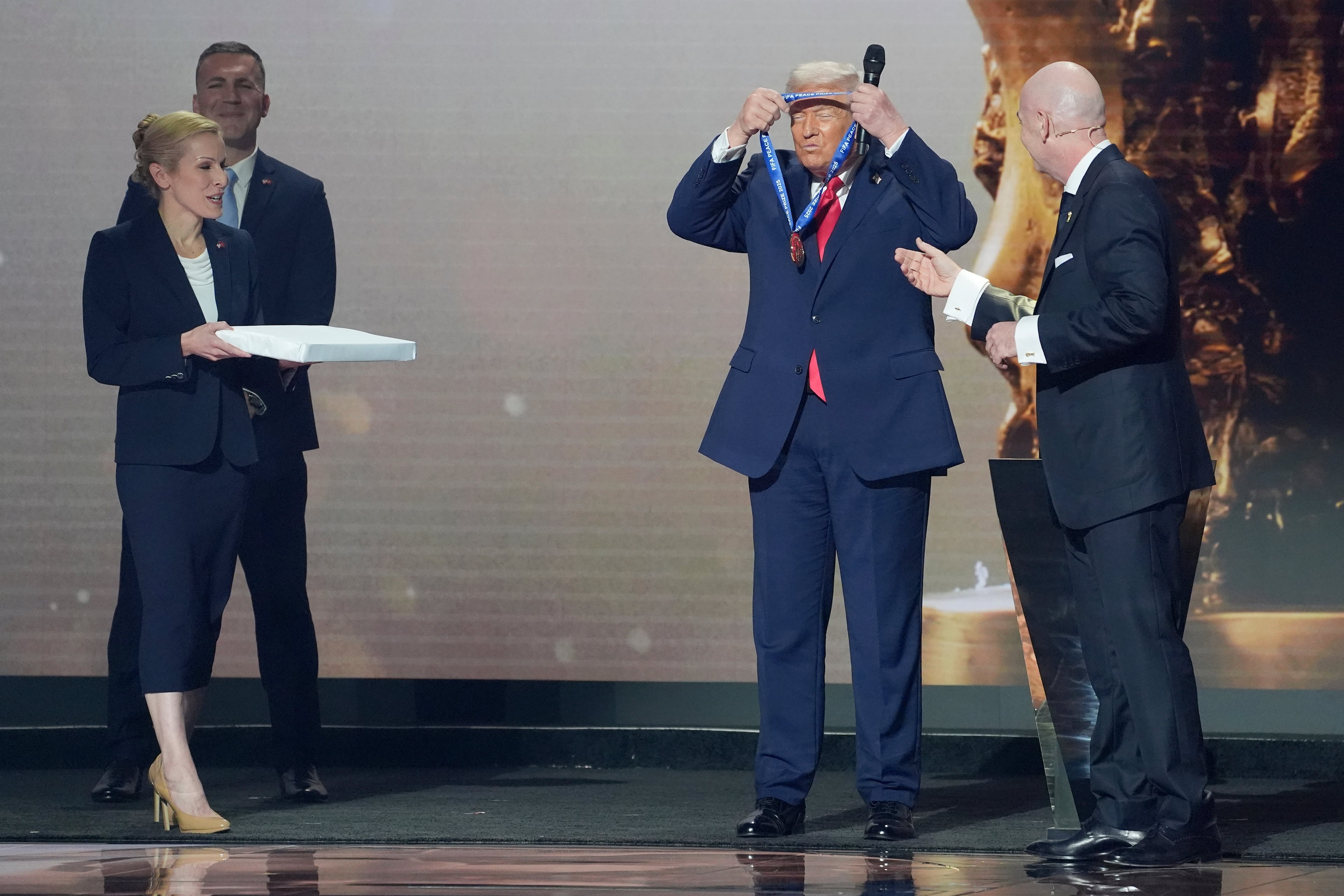 President Donald Trump is presented with the inaugural FIFA Peace Prize by FIFA President Gianni Infantino during the 2026 FIFA World Cup draw at the Kennedy Center, Friday, Dec. 5, 2025, in Washington. (AP Photo/Evan Vucci)