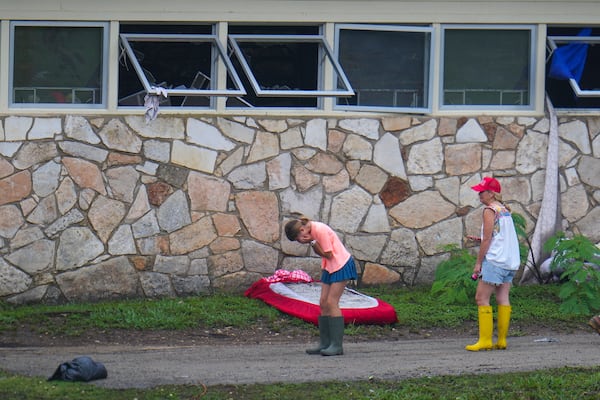 People react as they inspect an area outside sleeping quarters at Camp Mystic along the banks of the Guadalupe River after a flash flood swept through the area Sunday, July 6, 2025, in Hunt, Texas. (AP Photo/Julio Cortez)