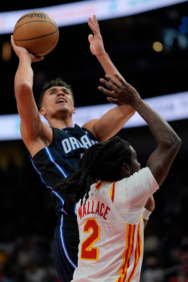 Orlando Magic guard Caleb Houstan (2) shoots against Atlanta Hawks guard Keaton Wallace (2) during the first half of an NBA basketball game, Sunday, April 13, 2025, in Atlanta. (AP Photo/Mike Stewart)