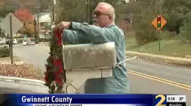 A neighbor of Cheryl Loving places a memorial item on her mailbox. Loving was found dead Wednesday at her Lawrenceville home.
