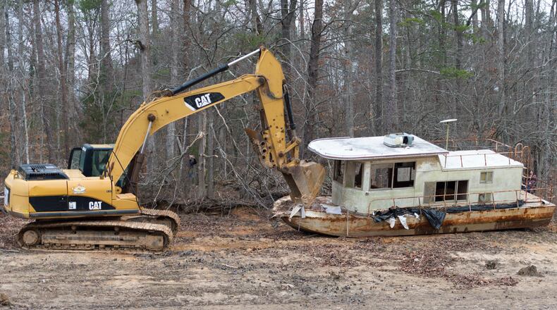 An abandoned houseboat, nicknamed the Museum Houseboat, is dragged away from Lake Lanier in Cumming, Georgia, on Monday, February 27, 2017. After being declared debris, the Lake Lanier Association was able to remove the boat, which is the third vessel removed with state allocated funds this fiscal year.