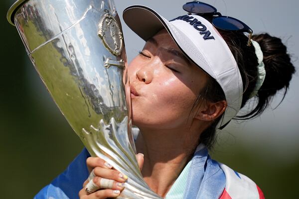 Grace Kim, of Australia, kisses her trophy after winning the Evian Championship women's golf tournament, in Evian, eastern France, Sunday, July 13, 2025. (AP Photo/Laurent Cipriani)