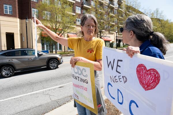 Chris Van Beneden, left, who worked at the Centers for Disease Control and Prevention for 25 years, and Julie Edelson, who worked there for 10, protest in support of the CDC in front of its Atlanta headquarters on Tuesday, April 1, 2025 after layoffs were announced. (AP Photo/Ben Gray)