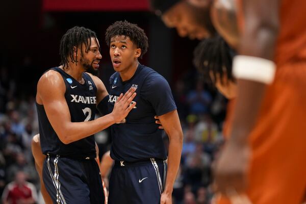 Xavier's Jerome Hunter (2) speaks with teammate Dailyn Swain during the second half of a First Four college basketball game against Texas in the NCAA Tournament, Wednesday, March 19, 2025, in Dayton, Ohio. (AP Photo/Jeff Dean)