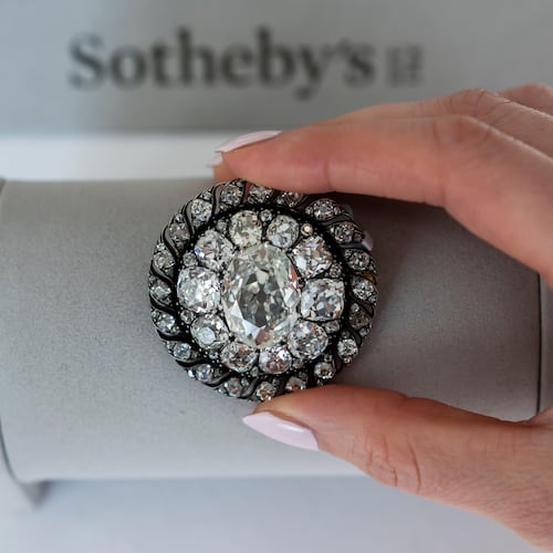 A Sotheby's employee displays an old mine-cut diamond brooch or pendant owned by Emperor Napoleon I, circa 1810, during a preview at Sotheby's in Geneva, Switzerland, Thursday, Nov. 6, 2025. (Martial Trezzini/Keystone via AP)
