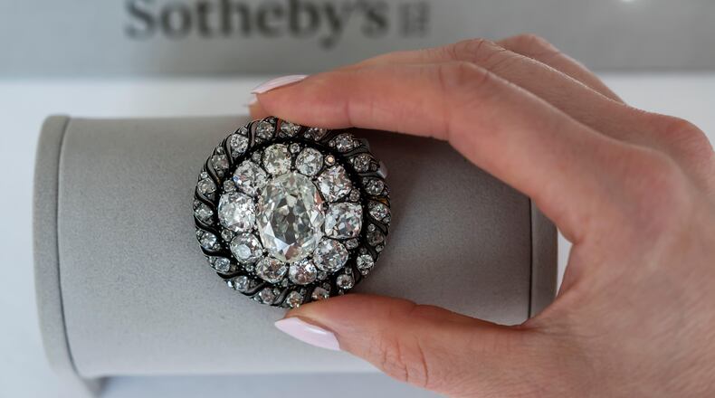 A Sotheby's employee displays an old mine-cut diamond brooch or pendant owned by Emperor Napoleon I, circa 1810, during a preview at Sotheby's in Geneva, Switzerland, Thursday, Nov. 6, 2025. (Martial Trezzini/Keystone via AP)