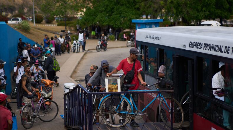 People load their bicycles onto a public bus to cross the Bay Tunnel in Havana, Wednesday, April 8, 2026. (AP Photo/Ramon Espinosa)