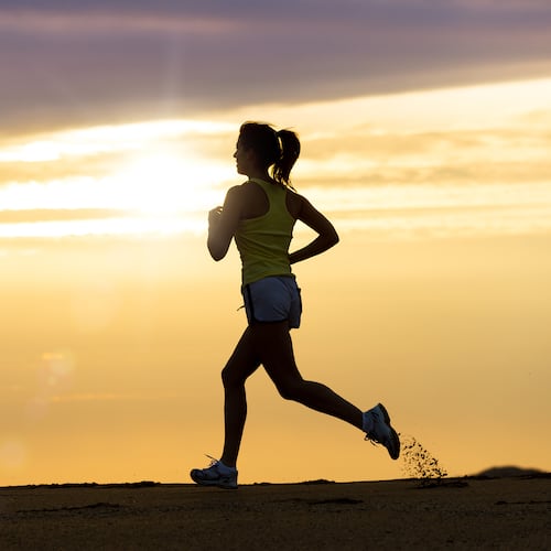 A woman runs on the beach at sunset. (Dreamstime/TNS)