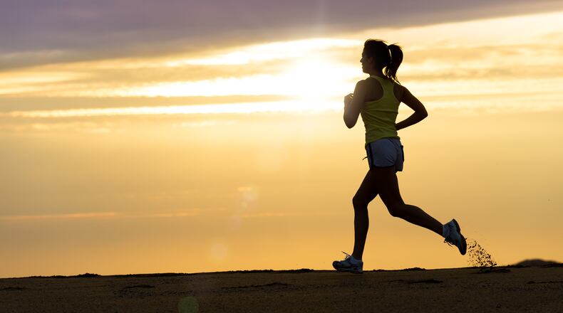A woman runs on the beach at sunset. (Dreamstime/TNS)