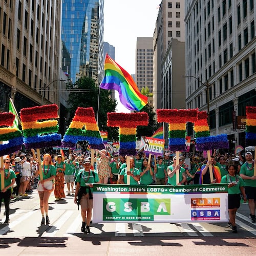 FILE - Marchers with the Greater Seattle Business Association, Washington State's LGBTQ+ and allied chamber of commerce, hold rainbow letters spelling out "Seattle," during the annual Seattle Pride Parade, June 25, 2023, in Seattle. (AP Photo/Lindsey Wasson, File)