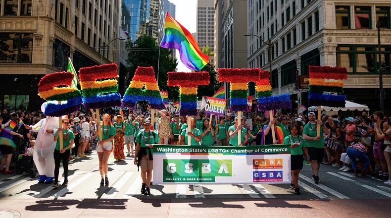 FILE - Marchers with the Greater Seattle Business Association, Washington State's LGBTQ+ and allied chamber of commerce, hold rainbow letters spelling out "Seattle," during the annual Seattle Pride Parade, June 25, 2023, in Seattle. (AP Photo/Lindsey Wasson, File)