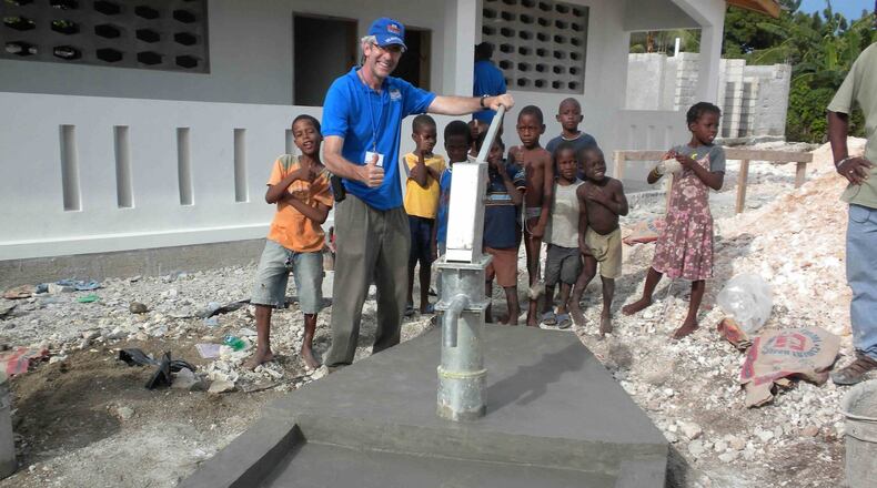 Civil rights attorney Ed Buckley has built more than 330 artesian wells and water reservoirs, providing water for nearly 350,000 people in Haiti since he founded the nonprofit Water Life Hope in 2005. He is pictured here with some of the region’s children at one of the newest wells. CONTRIBUTED