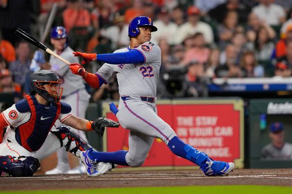 New York Mets' Juan Soto (22) hits a single against the Houston Astros during the first inning of an opening-day baseball game Thursday, March 27, 2025, in Houston. (AP Photo/David J. Phillip)