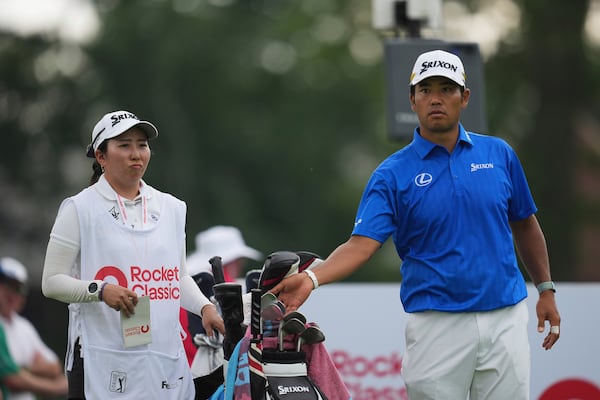 Hideki Matsuyama, of Japan, right, waits with his caddie Mei Inui at the ninth tee during the first round of the Rocket Classic golf tournament at the Detroit Golf Club, Thursday, June 26, 2025, in Detroit. (AP Photo/Paul Sancya)