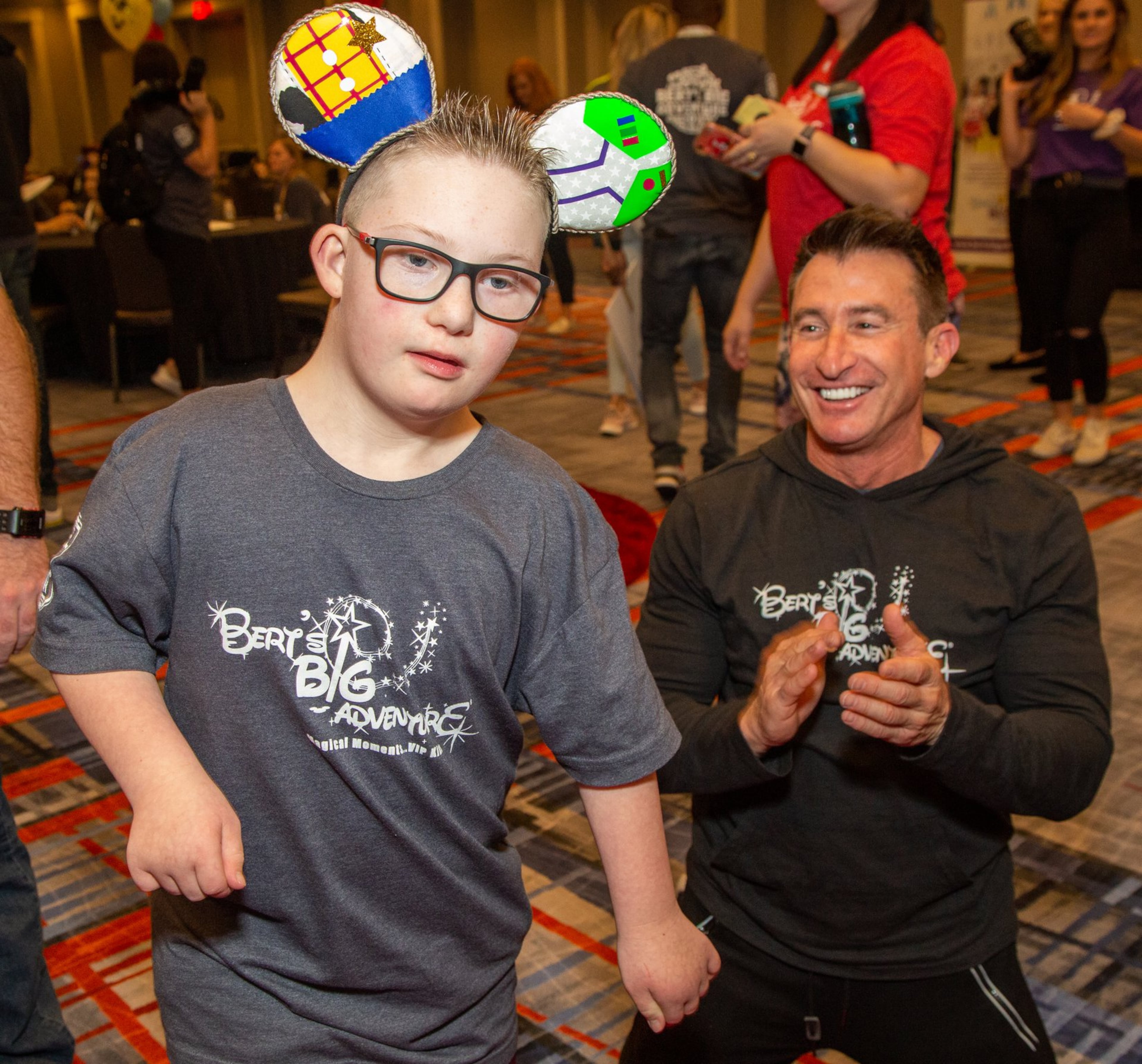 Sam Van Winkle (left) dances with Bert Weiss as families gather at the Hilton Atlanta Airport the night before heading to Disney World for 2020 Bert’s Big Adventure. Photo by Phil Skinner