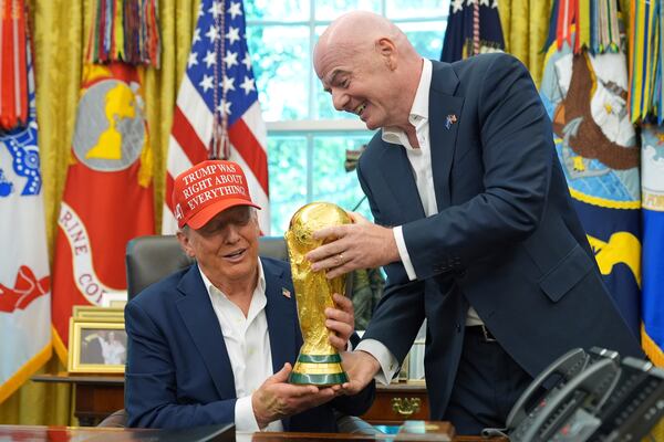FIFA President Gianni Infantino (right) hands the FIFA World Cup Winners Trophy to President Donald Trump during an announcement in the Oval Office of the White House, Friday, Aug. 22, 2025, in Washington. (Jacquelyn Martin/AP)