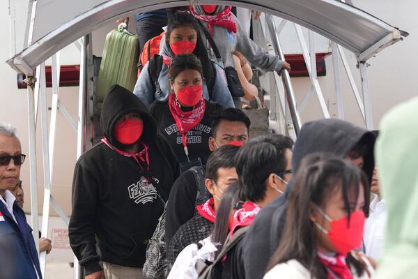 FILE - Indonesian nationals who had worked at scam centers in Myanmar disembark their plane upon arrival from Thailand, at Soekarno-Hatta International Airport in Tangerang, Indonesia, March 18, 2025. (AP Photo/Tatan Syuflana, Pool, File)
