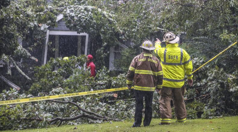 A tree falling on a home in Sandy Springs killed a man Monday. In Atlanta on Tuesday, four people were trapped in their homes by falling trees. JOHN SPINK/JSPINK@AJC.COM