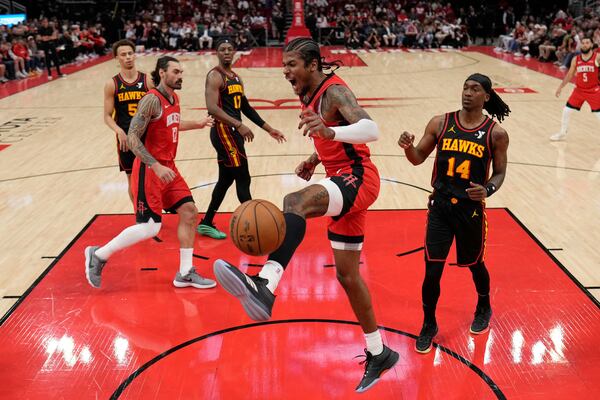Houston Rockets' Jalen Green, center, screams after dunking the ball against the Atlanta Hawks during the first half of an NBA basketball game Tuesday, March 25, 2025, in Houston. (AP Photo/David J. Phillip)
