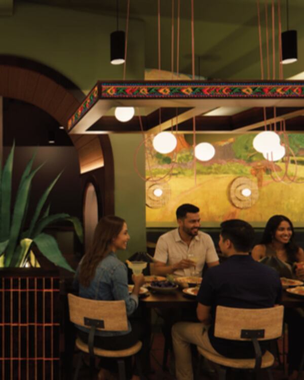 A group of people sit around a table at a modern Mexican restaurant.