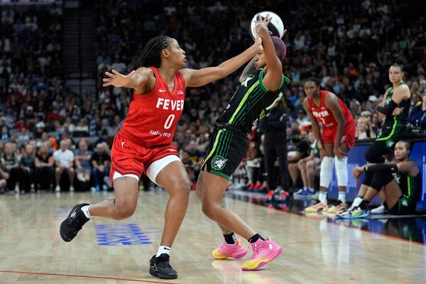 Minnesota Lynx guard Courtney Williams (10), right, handles the ball as Indiana Fever guard Kelsey Mitchell (0) defends during the first half of the WNBA Commissioner's Cup championship basketball game Tuesday, July 1, 2025, in Minneapolis. (AP Photo/Abbie Parr)