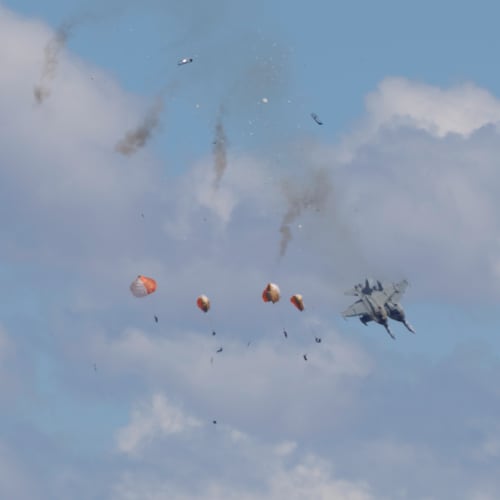 Crew members parachute down after two U.S. Navy planes collided during an air show at the Mountain Home Air Force Base, Sunday, May 17, 2026, near Mountain Home, Idaho. (Henk Zuurbier via AP)