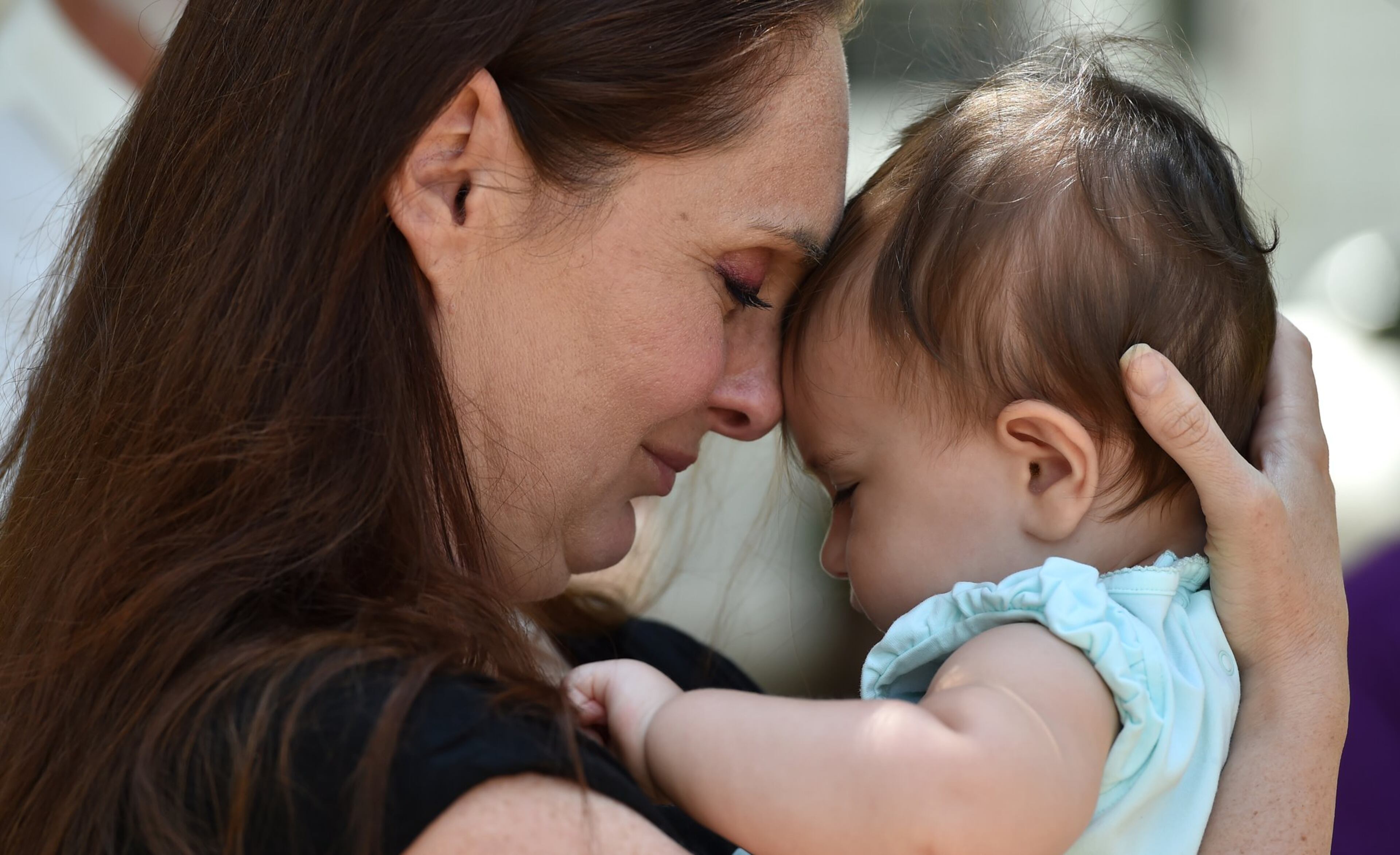 Camila Zolfaghari hugs her daughter Zoya after speaking at a news conference about the death of her husband in June 2016. The child is now 10 years old. (AJC file photo)