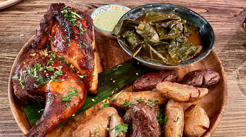 Pollo a la brasa is served with collard greens and fingerling potatoes at Tio Lucho’s. Angela Hansberger for The Atlanta Journal-Constitution
