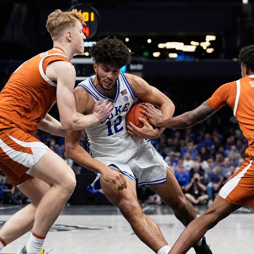 Duke forward Cameron Boozer drives to the basket between Texas center Matas Vokietaitis, left, and forward Dailyn Swain during the second half of an NCAA college basketball game, Tuesday, Nov. 4, 2025, in Charlotte, N.C. (AP Photo/Chris Carlson)