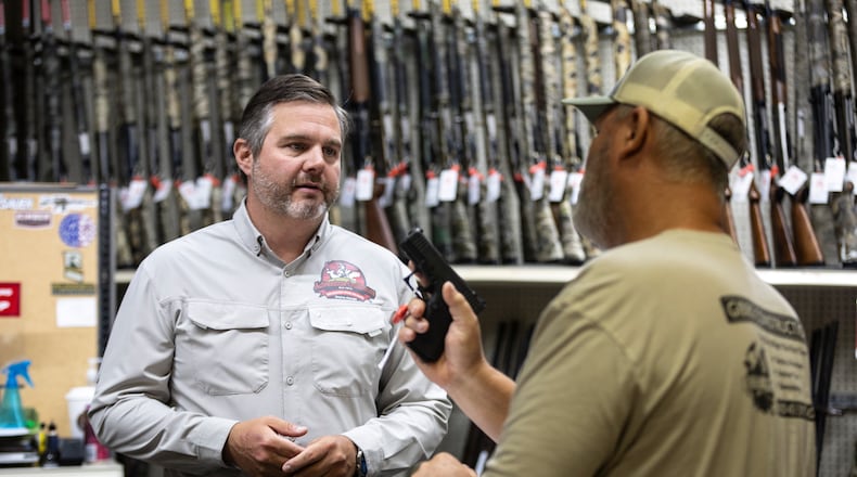 Adventure Outdoors general manager and part-owner Eric Wallace, left, helps Bobby Gibbs decide on a potential gun purchase in Smyrna on Tuesday, July 23, 2024. Sales are up substantially, according to Wallace. “A lot of our customers are saying that if the Secret Service, which is known to be one of the best law enforcement agencies in the world, can’t protect a former president, how is our government going to protect us if something serious were to happen?” Wallace said. (Steve Schaefer / AJC)