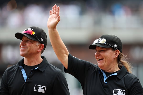 Umpire Jen Pawol (right) waves to the crowd after Game 1 of Saturday's doubleheader at Truist Park.