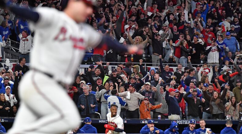 The Braves' Austin Riley (left) runs to first as Ozzie Albies scores the game-winning run.  (Hyosub Shin / Hyosub.Shin@ajc.com)