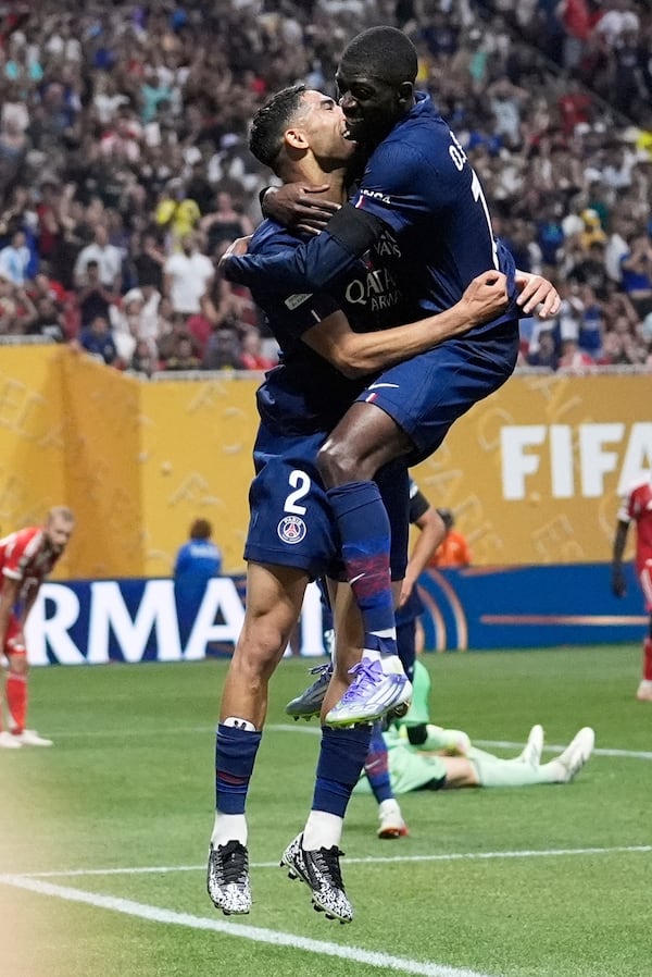 Paris Saint-Germain's Ousmane Dembele celebrates his team's second goal with Paris Saint-Germain's Achraf Hakimi during the Club World Cup quarterfinal soccer match between PSG and Bayern Munich in Atlanta, Saturday, July 5, 2025. (AP Photo/Brynn Anderson)