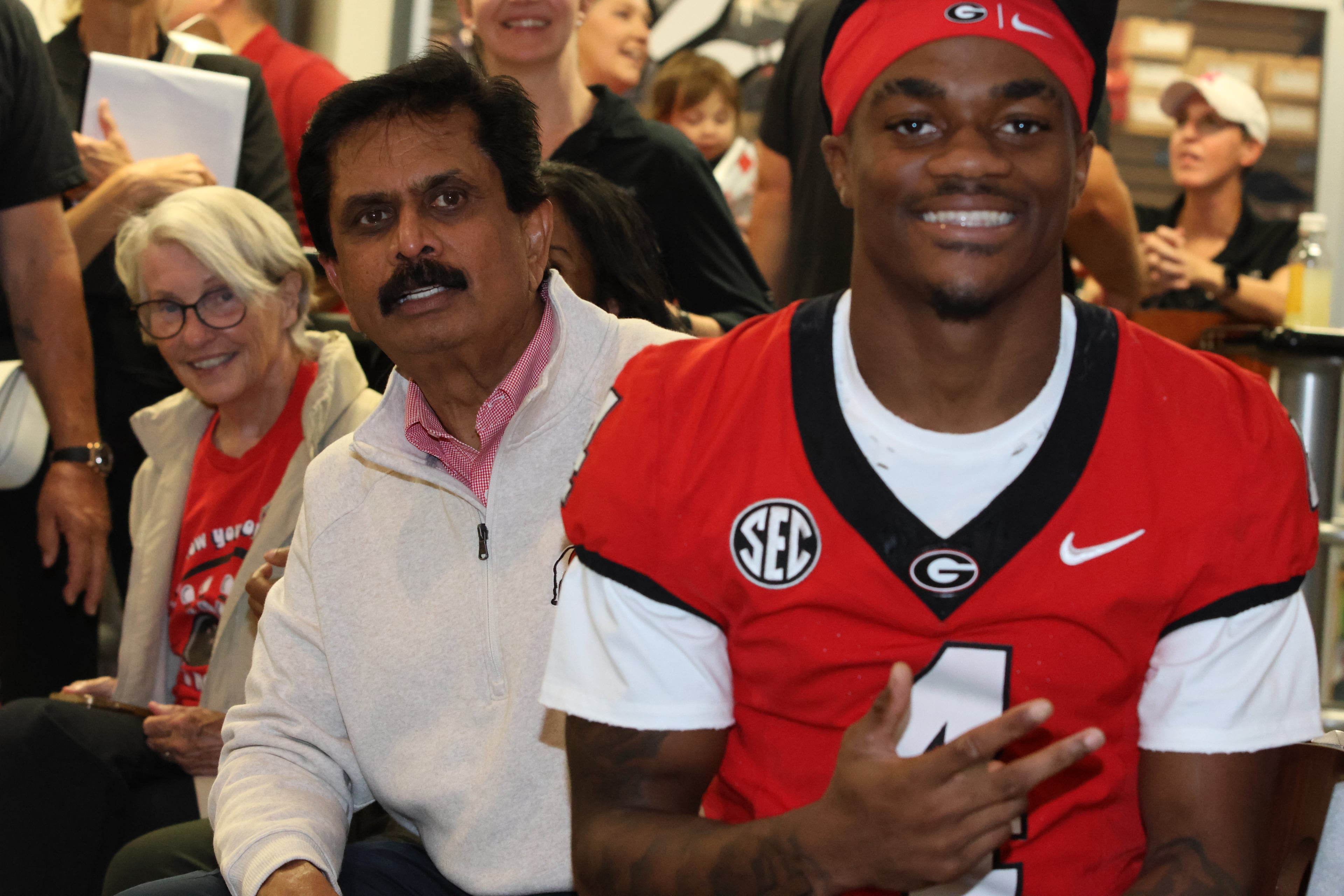 Dr. Anumantha Kanthasamy (center), UGA professor of physiology and pharmacology and director of the Isakson Center for Neurological Disease Research, watches the action next to KJ Bolden during the third annual Chick-fil-A Dawg Bowl fundraiser at Showtime Bowl in Athens on Wednesday, Oct. 22, 2025. The Dawg Bowl has raised more than $2 million in the past three years for the Isakson Center’s research into Parkinson’s and Crohn’s diseases. (C.J. Bartunek for the AJC)