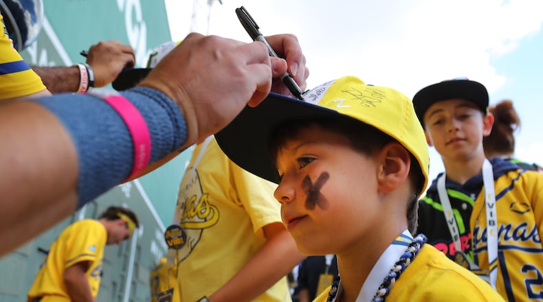 Coen Hosford, 8, gets his hat autographed in the outfield before a Savannah Bananas game last June at Boston's Fenway Park. The barnstorming baseball team will play in 18 Major League stadiums in 2025. (John Tlumacki/The Boston Globe)