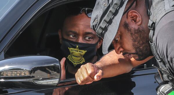 April 30, 2021 Clayton County: Clayton County Sheriff Victor Hill (left) talks with a deputy outside the QuikTrip where authorities again descended on College Park to search for a wanted man Friday morning, April 30, 2021 hours after an Arizona murder suspect was recaptured at the end of a 16-hour manhunt. The search for Georgia inmate Devonte Detaun Ross took place in the area of North Clayton High School, just south of Hartsfield-Jackson International Airport. According to the Clayton County sheriff, Ross was on his way to a state prison when his transport officers stopped to get him something to eat at a QuikTrip on Riverdale Road and he escaped. Ross was most recently housed at the Atlanta Transitional Center following stints in prison on burglary and narcotics trafficking convictions out of Douglas and Cobb counties, state records show. He was being transferred to back to prison after violating requirements of his sentence, the Clayton sheriff’s office said in a public advisory. Ross, described as 5 feet tall and about 135 pounds, could still be handcuffed in front of his body and wearing chains around his waist. At the time of his escape, he was wearing a black hoodie, black pants and black shoes with orange stripes, the sheriff’s office said. Five nearby schools are on “soft lockdown” as the search continues, according to Clayton school officials. North Clayton High, Clayton Middle, Northcutt Elementary, Oliver Elementary and West Clayton Elementary are keeping exterior doors locked as school operations continue inside. “Any escapee regardless of charges should be considered potentially dangerous,” the sheriff’s office said. “If spotted, do not approach and dial 911 immediately. Everyone who lives and work(s) in this area should keep their doors locked and stay vigilant.” (John Spink / John.Spink@ajc.com)

