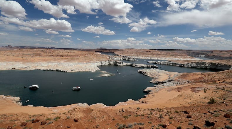 Boats float on Lake Powell, a vast reservoir of Colorado River water situated near the Utah-Arizona border. A white "bathtub ring" on the lake's shores show how much water levels have dropped during a decade of severe drought. (Luis Sinco/Los Angeles Times/TNS)