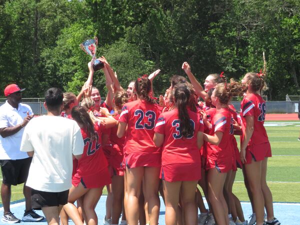 Members of the Milton Eagles girls lacrosse team celebrate upon receiving the GHSA Division II championship trophy Saturday, May 17, 2025, at Denmark High in Alpharetta. The Eagles defeated the Creekview Grizzlies 17-5 for their seventh straight state title, and 18th overall.