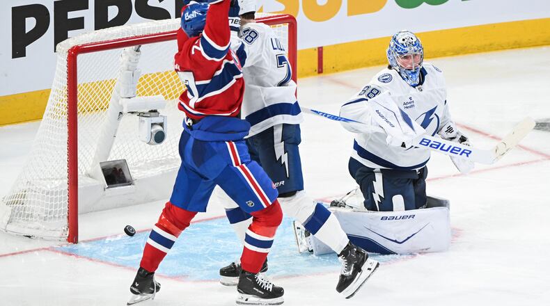 Montreal Canadiens' Kirby Dach (77) reacts to a goal by teammate Lane Hutson against Tampa Bay Lightning goaltender Andrei Vasilevskiy (88) during overtime in an NHL hockey playoff game in Montreal, Friday, April 24, 2026. (Graham Hughes/The Canadian Press via AP)