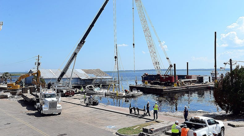 Cranes are set up on the waterfront in St. Mary’s as the U.S. Coast Guard and contractors remove boats, sunken and grounded by Tropical Storm Irma, to get the docks repaired and operating again. Photo from Sept. 27 2017. Terry Dickson/Florida Times-Union