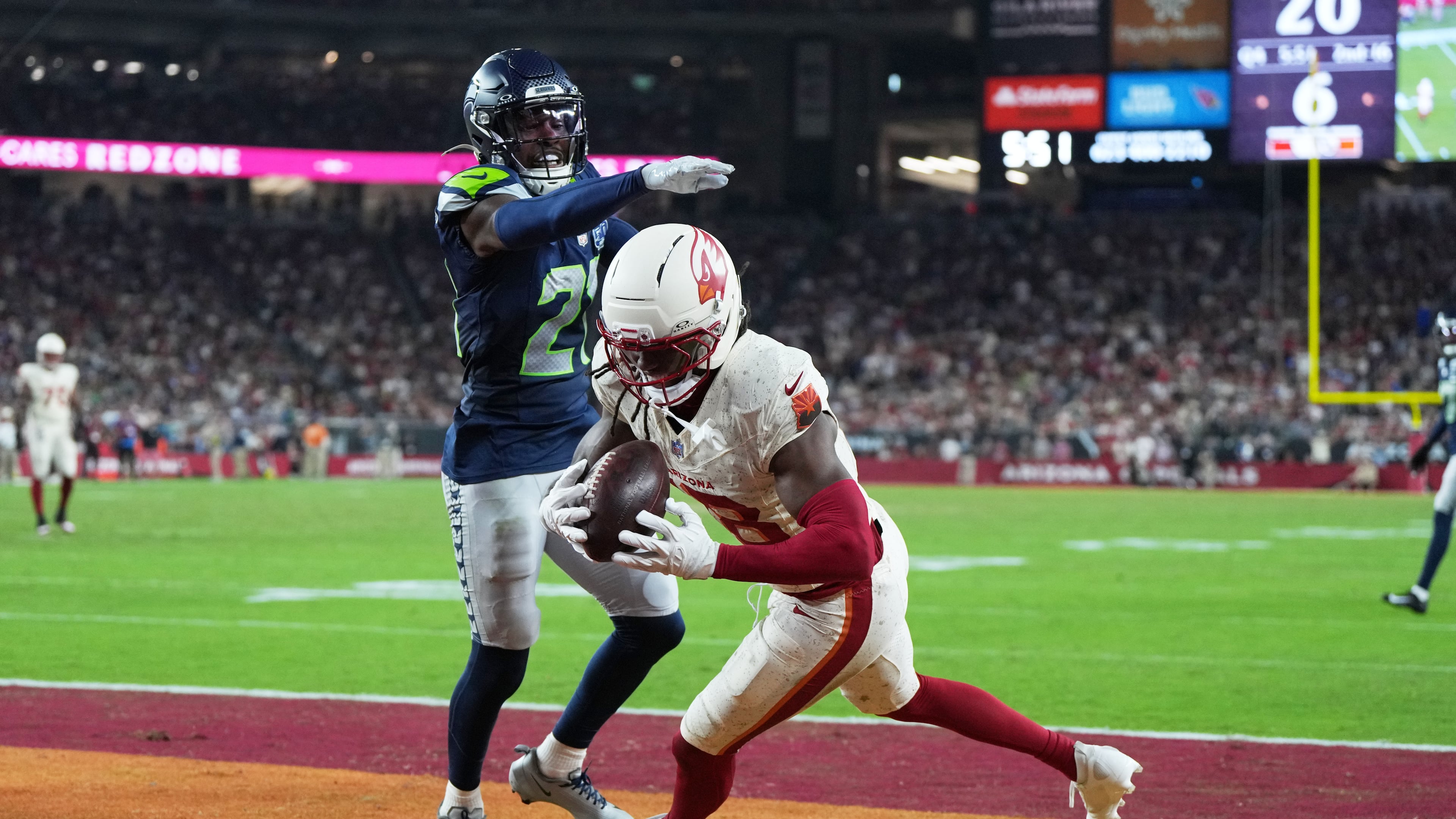 Arizona Cardinals wide receiver Marvin Harrison Jr., right, catches a touchdown pass as Seattle Seahawks cornerback Devon Witherspoon defends during the second half of an NFL football game Thursday, Sept. 25, 2025, in Glendale, Ariz. (AP Photo/Rick Scuteri)